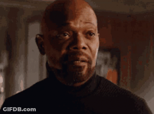 Bald Man In Black Turtleneck Looking At Camera GIF