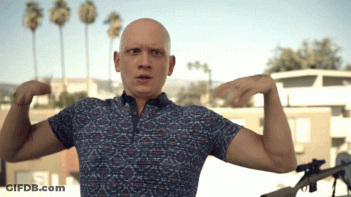 Bald Man In Blue Shirt Flexing Arms GIF