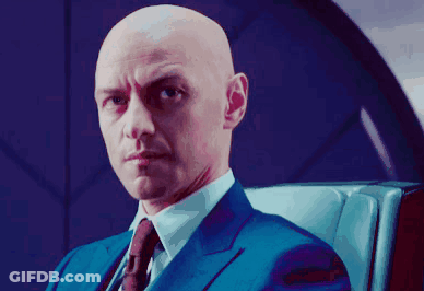 Bald Man In Blue Suit And Tie Sitting In Chair GIF