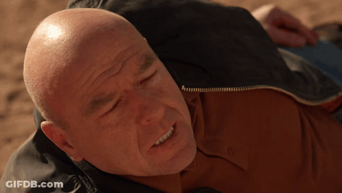 Bald Man In Brown Shirt Laying On Ground GIF
