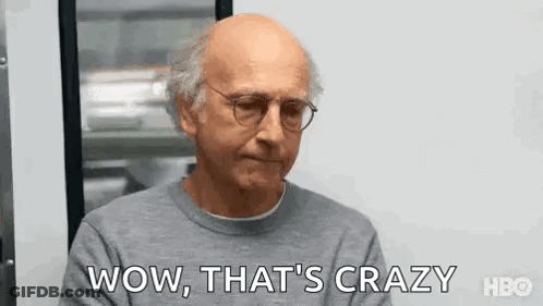 Bald Man In Glasses And Gray Sweater Saying Wow At Window GIF