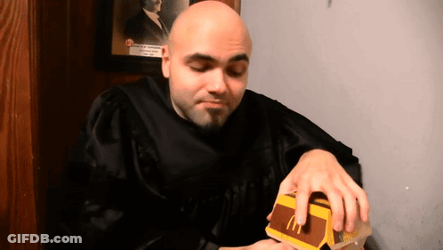 Bald Man In Graduation Gown Eating McDonald's Hamburger GIF