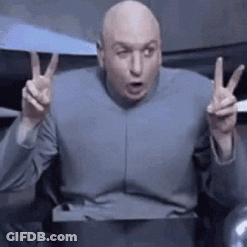 Bald Man In Gray Suit Giving Peace Sign GIF
