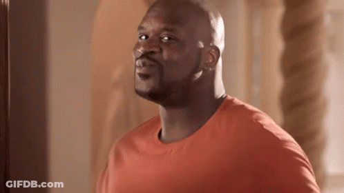 Bald Man In Orange Shirt Looking At Camera GIF