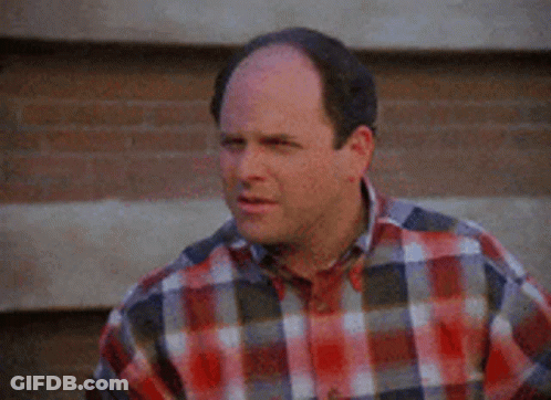 Bald Man In Plaid Shirt By Brick Wall GIF