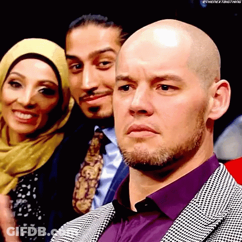 Bald Man In Purple Shirt In Front Of Group GIF