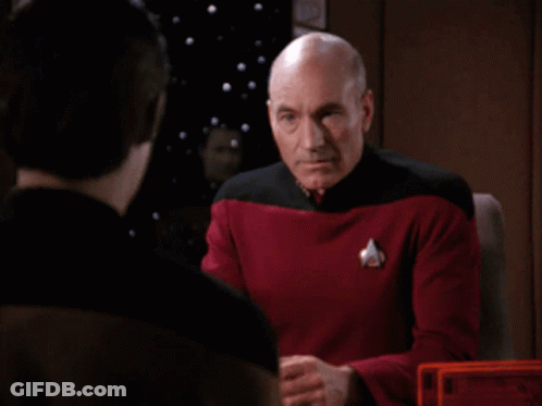 Bald Man In Red And Black Uniform Covering Face GIF
