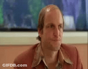 Bald Man In Red Jacket Sitting At Table GIF