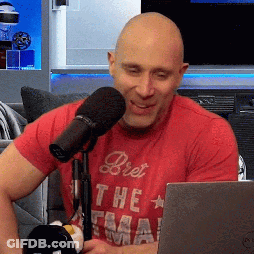 Bald Man In Red Shirt Bret At Microphone GIF