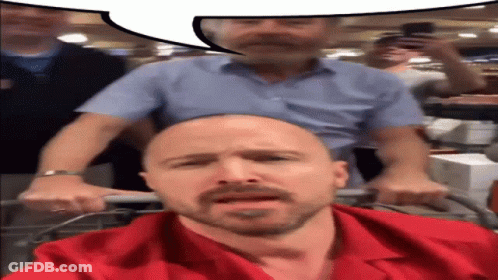 Bald Man In Red Shirt Pushed By Another Man GIF