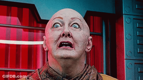 Bald Man In Scarf Looking Up At Camera GIF