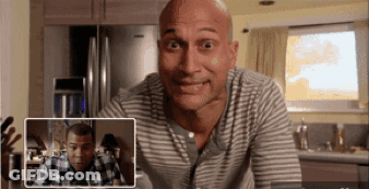 Bald Man In Striped Shirt Looking At Another Bald Man GIF