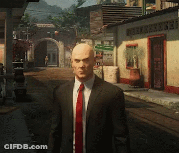 Bald Man In Suit And Red Tie Standing In Street GIF