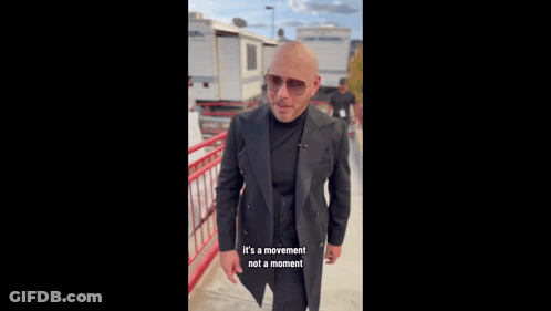 Bald Man In Suit And Sunglasses By Railing GIF
