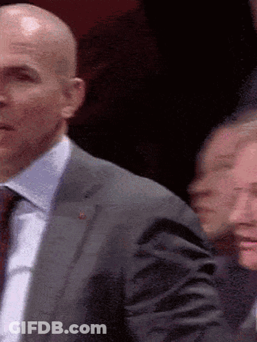 Bald Man In Suit And Tie In Crowd GIF
