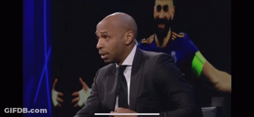 Bald Man In Suit And Tie In Front Of Soccer Player GIF