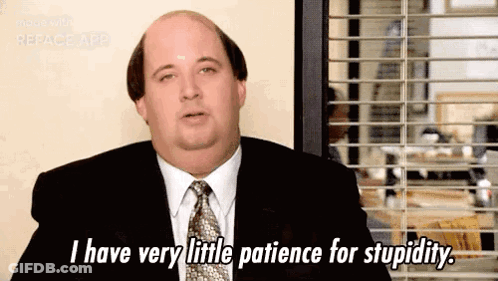 Bald Man In Suit And Tie Sitting By Window GIF