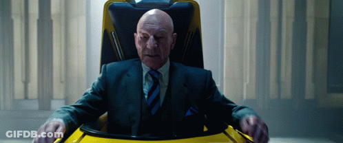 Bald Man In Suit And Tie Sitting In Chair GIF