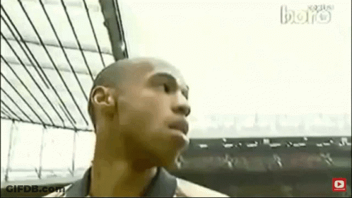 Bald Man In Suit And Tie Sitting In Front Of Soccer Player GIF