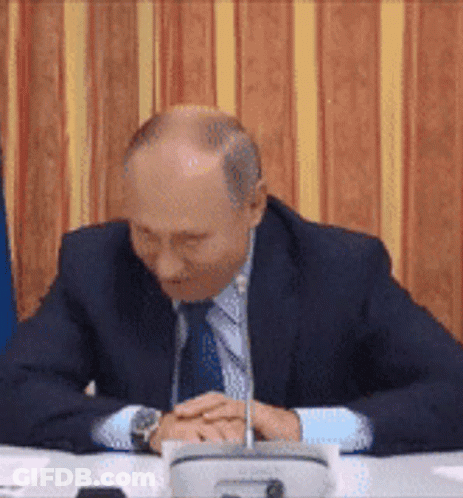 Bald Man In Suit And Tie With Folded Hands GIF