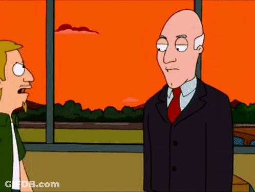 Bald Man In Suit Next To Blonde Man In Green Shirt GIF