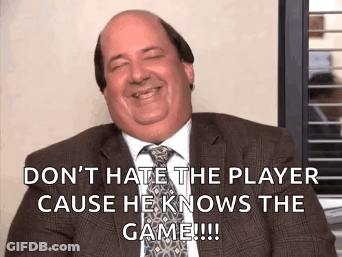 Bald Man In Suit Saying Don't Hate The Player Cause He Knows The Game GIF