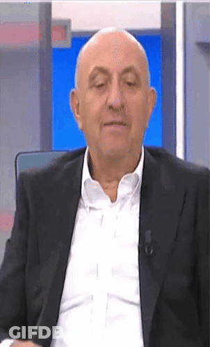 Bald Man In Suit Sitting In Front Of Blue Screen GIF