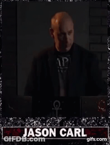 Bald Man In Suit Standing By Laptop GIF