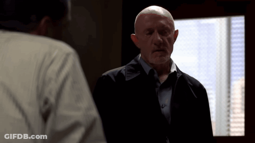 Bald Man In Suit Talking To Another Man GIF