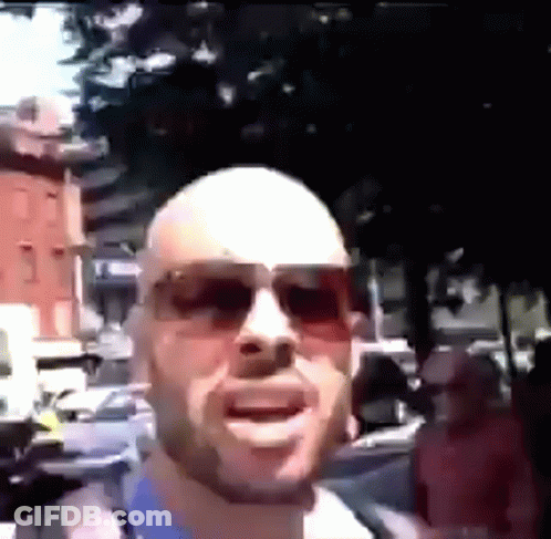 Bald Man In Sunglasses On Crowded Street GIF