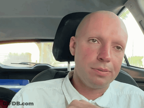Bald Man In White Shirt Driving GIF