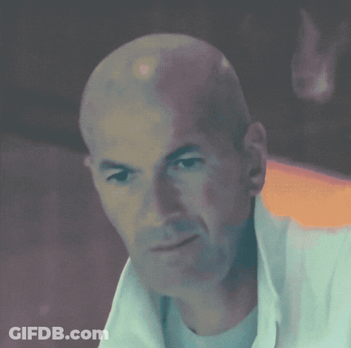 Bald Man In White Shirt Looking At Camera GIF