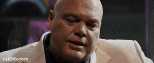 Bald Man In White Suit And Blue Tie Looking Down GIF
