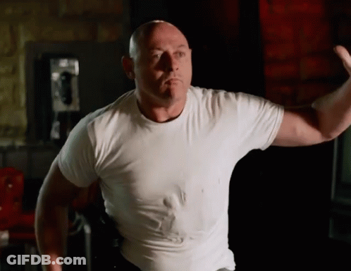 Bald Man In White T-Shirt Flexing Muscles GIF