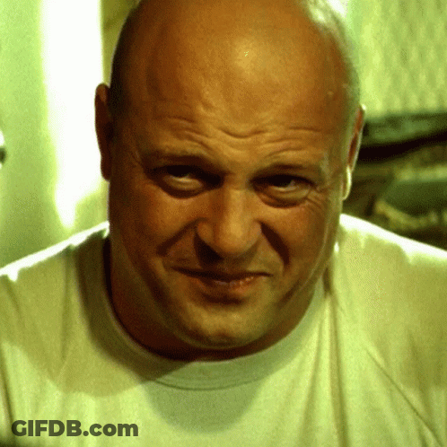 Bald Man In White T-Shirt Looking At Camera GIF