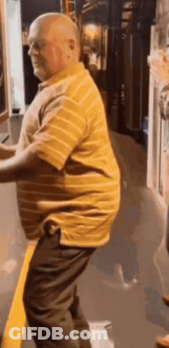 Bald Man In Yellow Striped Shirt And Black Pants GIF