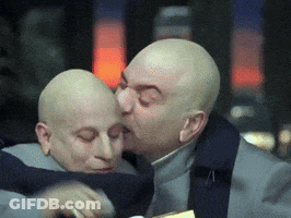 Bald Man Kisses Another Bald Man On Forehead GIF