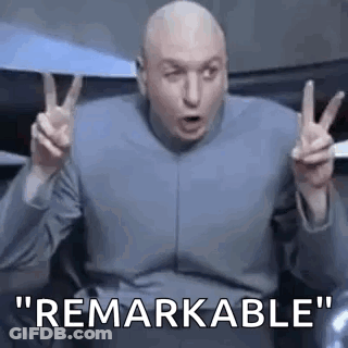 Bald Man Making Peace Sign While Sitting In Chair GIF