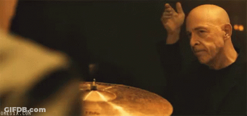 Bald Man Playing Drums In Dark Room GIF