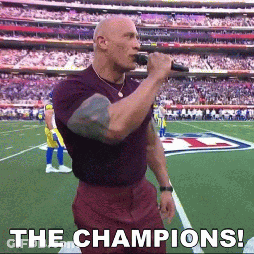Bald Man Singing Into Microphone On Football Field Saying The Champions GIF