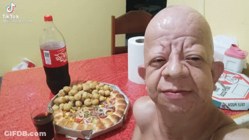 Bald Man Sitting At Table With Coca Cola And Pizza GIF