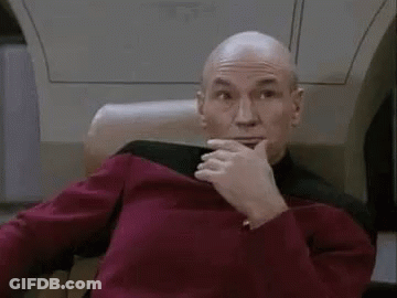 Bald Man Sitting In Chair With Hand On Chin GIF