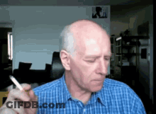 Bald Man Smoking Cigarette In Blue Shirt GIF