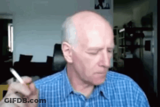 Bald Man Smoking Cigarette In Blue Shirt GIF