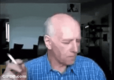 Bald Man Smoking Cigarette In Blue Shirt GIF