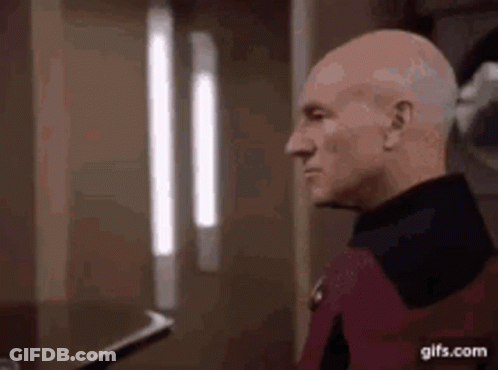Bald Man Standing In Front Of Window GIF