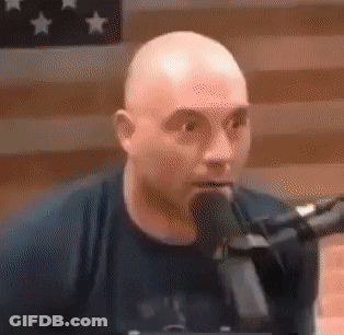 Bald Man Talking Into Microphone In Black Shirt GIF