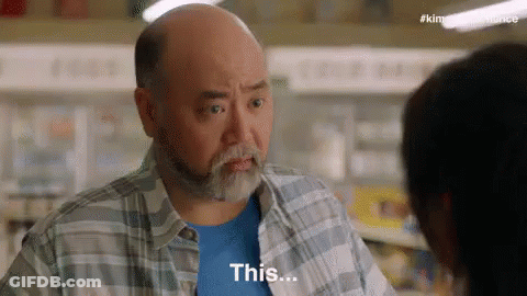 Bald Man Talking To Woman In Grocery Store Saying This GIF