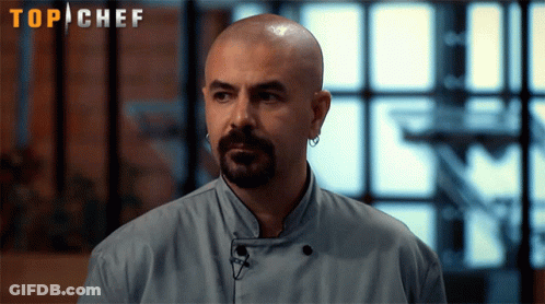 Bald Man With Beard And Earrings In Front Of Top Chef Sign GIF