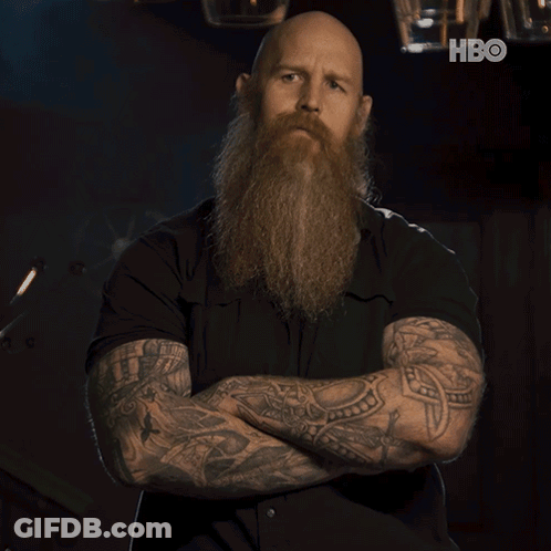 Bald Man With Beard And Tattoos Arms Crossed In Front Of HBO Logo GIF